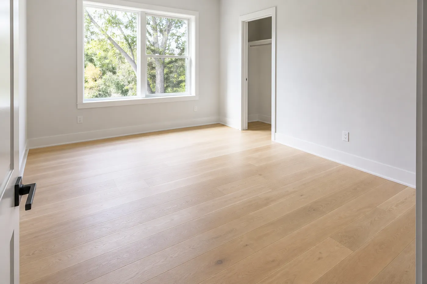 Piso de tablón de roble blanqueado plastificado en un dormitorio luminoso